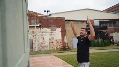 Wesley Mast, owner and president of Coppes Napanee, gestures next to a giant replica of a Hoosier cabinet (see below) in Nappanee, Ind., Thursday, Aug. 6, 2026.