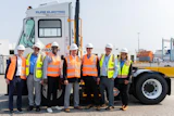 Orange EV and APM Terminals team members gather alongside an Orange EV electric terminal truck.