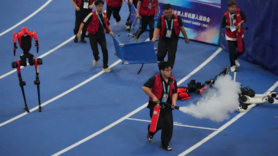 Officials extinguish a fire of a Humanoid robot after hitting the barrier at the end of the 100 meter final race during the World Humanoid Robot Games in Beijing, Wednesday, Aug. 26, 2026.