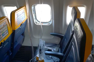 This undated photo provided by the National Transportation Safety Board on Thursday, Aug. 13, 2026, shows the shattered window on a Ryanair plane that was broken by a stray engine part shortly after takeoff, causing a man's head to be sucked into the hole.