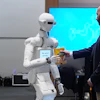 A man receives a box of chocolate powder drink from a robot during a demonstration of AI-based robotics in Europe at the European Parliament in Brussels, Wednesday, Sept. 2, 2026.