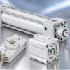 Industrial pneumatic cylinders and compact actuators with metal fittings displayed on reflective surface