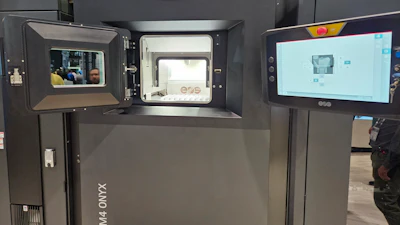 3D printer with open chamber displaying printing platform and control interface