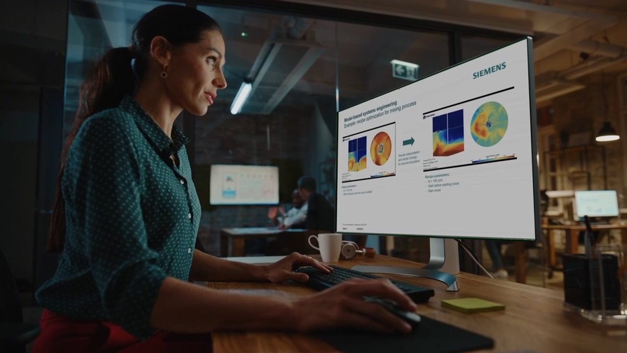 Woman reviewing Siemens technical presentation with thermal and data visualization charts on office monitor