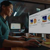 Woman reviewing Siemens technical presentation with thermal and data visualization charts on office monitor