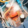 Close-up of circuit board interior with red LED component, resistors, and white wiring visible