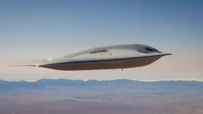 Futuristic silver aircraft with streamlined design flying over desert landscape and distant mountains