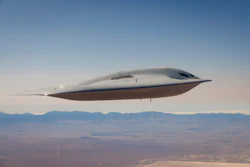 Futuristic silver aircraft with streamlined design flying over desert landscape and distant mountains