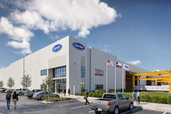Modern Carrier HVAC dealership facility with white exterior, blue signage, and yellow equipment canopy under blue sky