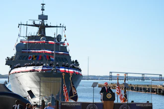 USCGC Maritime Dominance naval vessel at commissioning ceremony with officials and American flags at waterfront dock