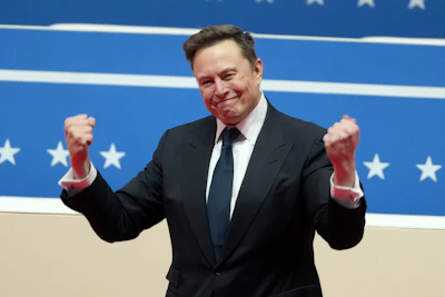 Man in black suit with fist gestures against patriotic blue background with stars