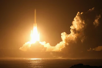 Rocket launching at night with bright engine flames piercing through golden clouds over the ocean