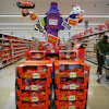 Halloween candy display in retail store featuring Reese's, Kit Kat, and Hershey's products with orange and purple promotional signage.