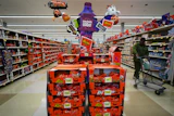 Halloween candy display in retail store featuring Reese's, Kit Kat, and Hershey's products with orange and purple promotional signage.