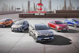 Five VinFast electric vehicles displayed on a rooftop with city skyline backdrop and Manufacturing Now branding
