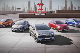 Five VinFast electric vehicles displayed on a rooftop with city skyline backdrop and Manufacturing Now branding