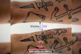 Tattoo comparison showing black ink under visible light and UV-reactive purple pigment under ultraviolet light on forearm