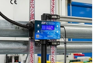 EFC blue control device mounted on industrial factory equipment with colorful overhead cables and structural beams