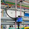 EFC blue control device mounted on industrial factory equipment with colorful overhead cables and structural beams
