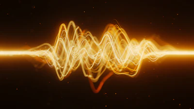 Golden glowing waveform visualization with oscillating sound waves on dark background
