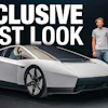 Exclusive first look at futuristic white concept car with two men standing beside it against dark background