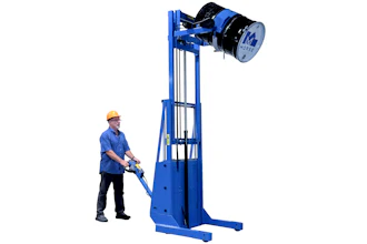Worker operating blue industrial drum lifter with safety equipment for material handling