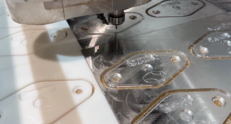 CNC machining workstation with white plastic components and metal parts with protective film during manufacturing process
