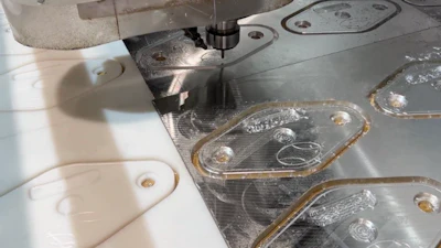 CNC machining workstation with white plastic components and metal parts with protective film during manufacturing process