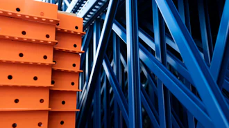 Orange and blue industrial warehouse racking system with metal shelving and structural beams