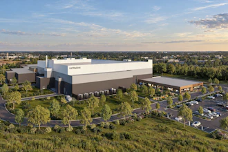 Hitachi corporate manufacturing facility with modern architecture, surrounded by landscaping and parking lot