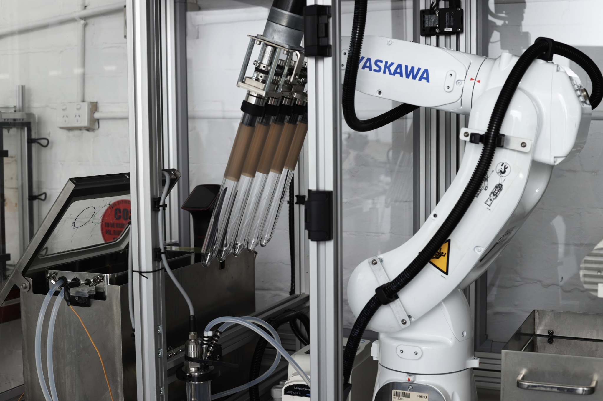 ASKAWA industrial robotic arm with tool changer mounted in manufacturing enclosure