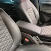 Luxury car interior with quilted leather seats in light gray and black tones, center console visible