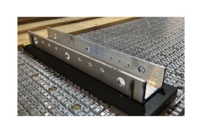 Metal channel track with mounting holes and black base on textured surface