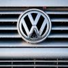 Volkswagen logo on wet vehicle grille with chrome trim